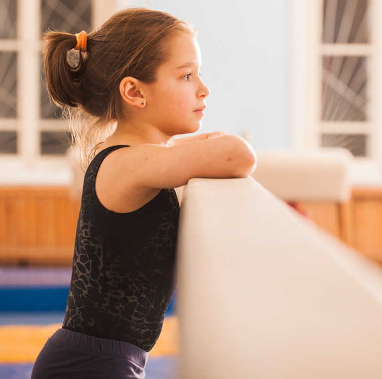 Young gymnast practicing at the bars