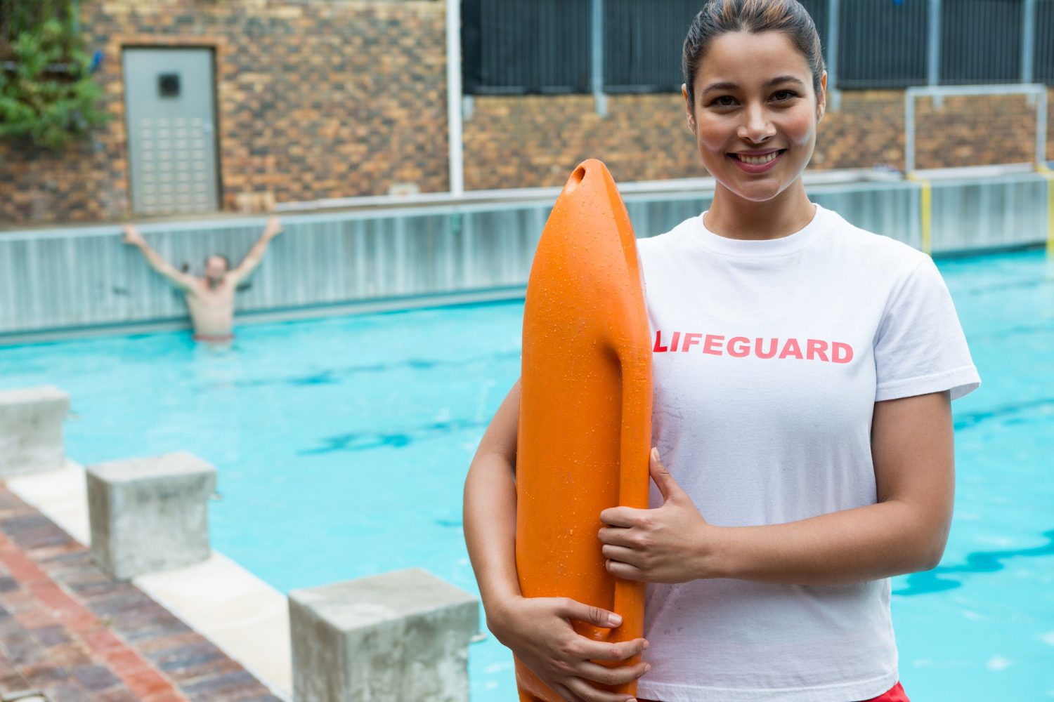 Lifeguard in uniform watching a swimmer in the lanes