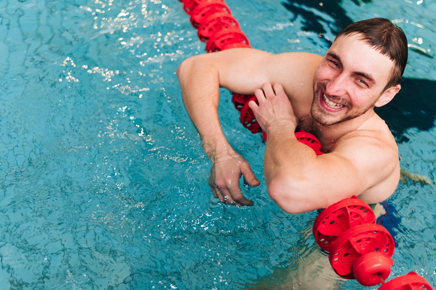 Lifeguard supporting a swimmer with a rescue tube in the water
