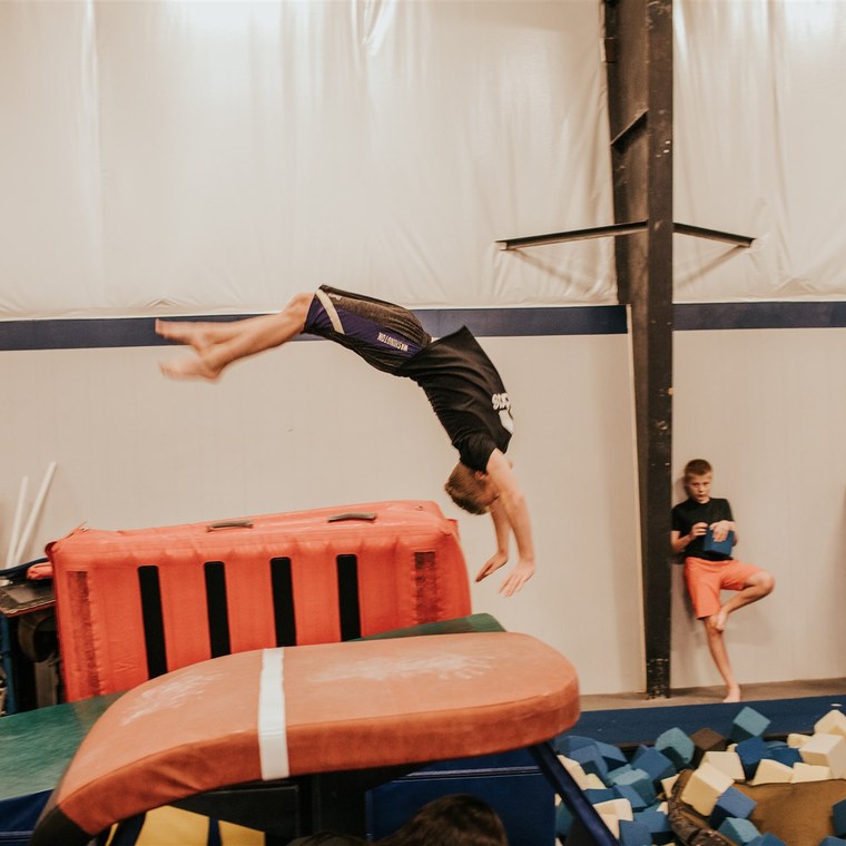 An athlete flying over the vault table