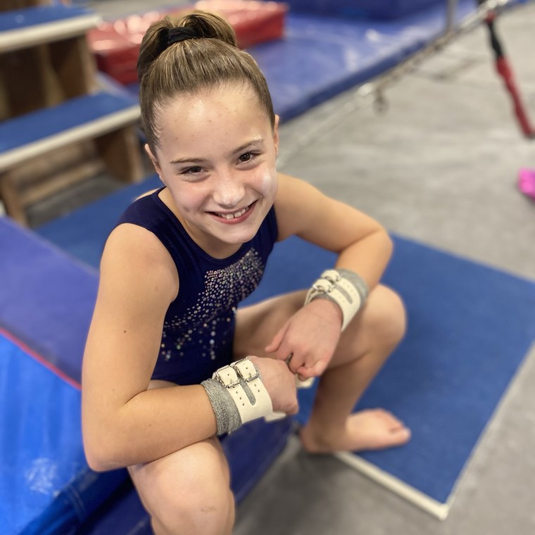 A gymnast resting between bar routines