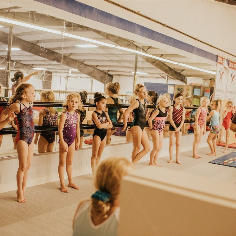A class lined up at the ballet barre