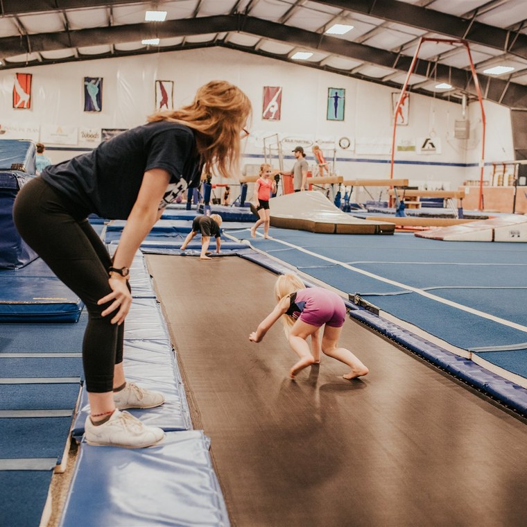 A coach spotting a tumbling pass