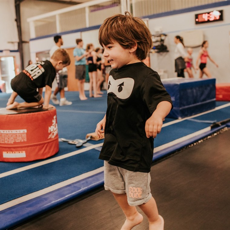 A young athlete running the vault runway